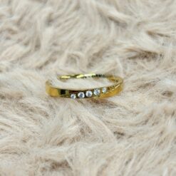 Gold ring with embedded diamonds resting on light beige fur.
