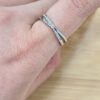 Close-up of a silver ring with small diamonds worn on the finger