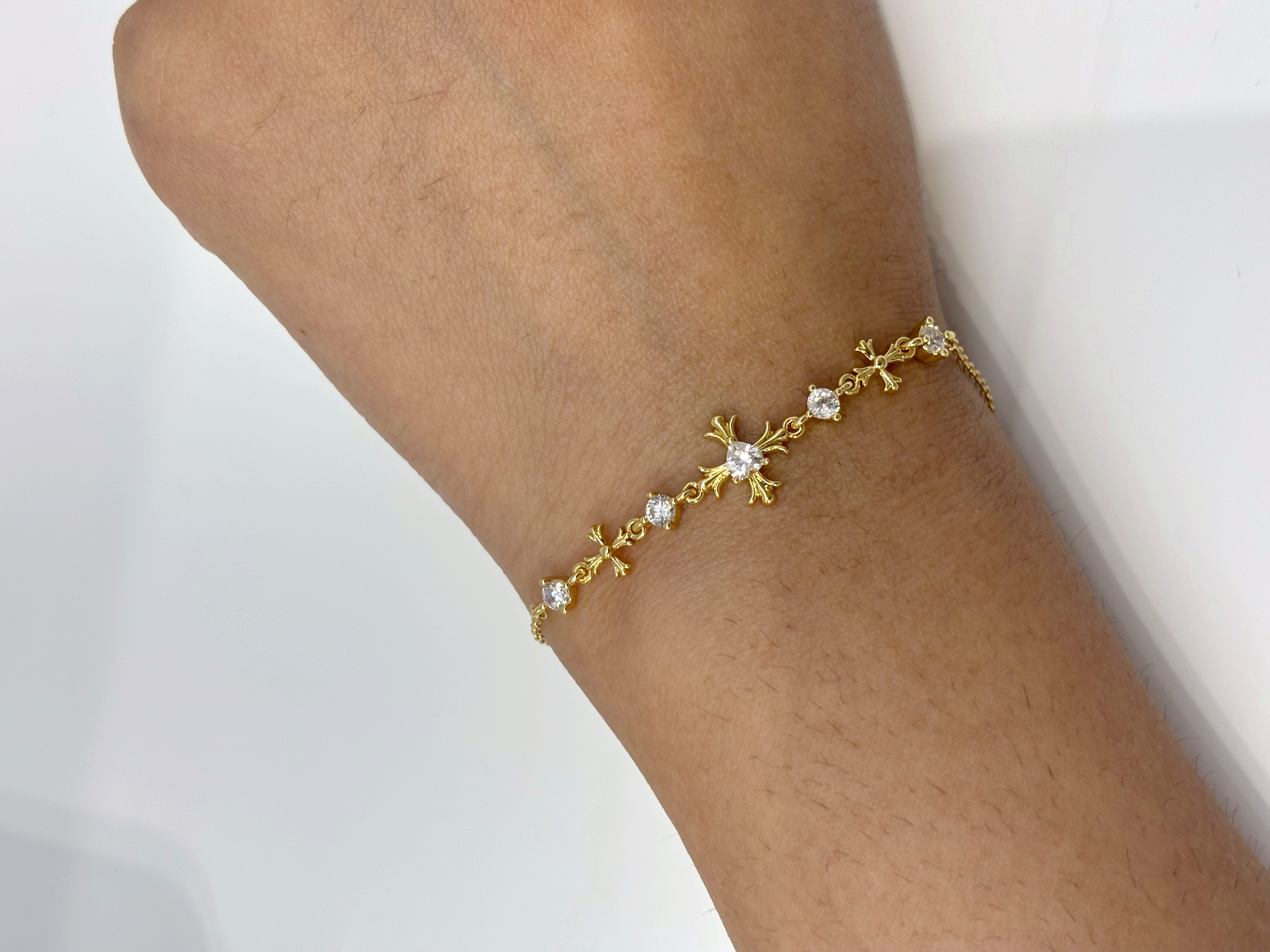 Cross and Crystal gold plated bracelet worn on wrist