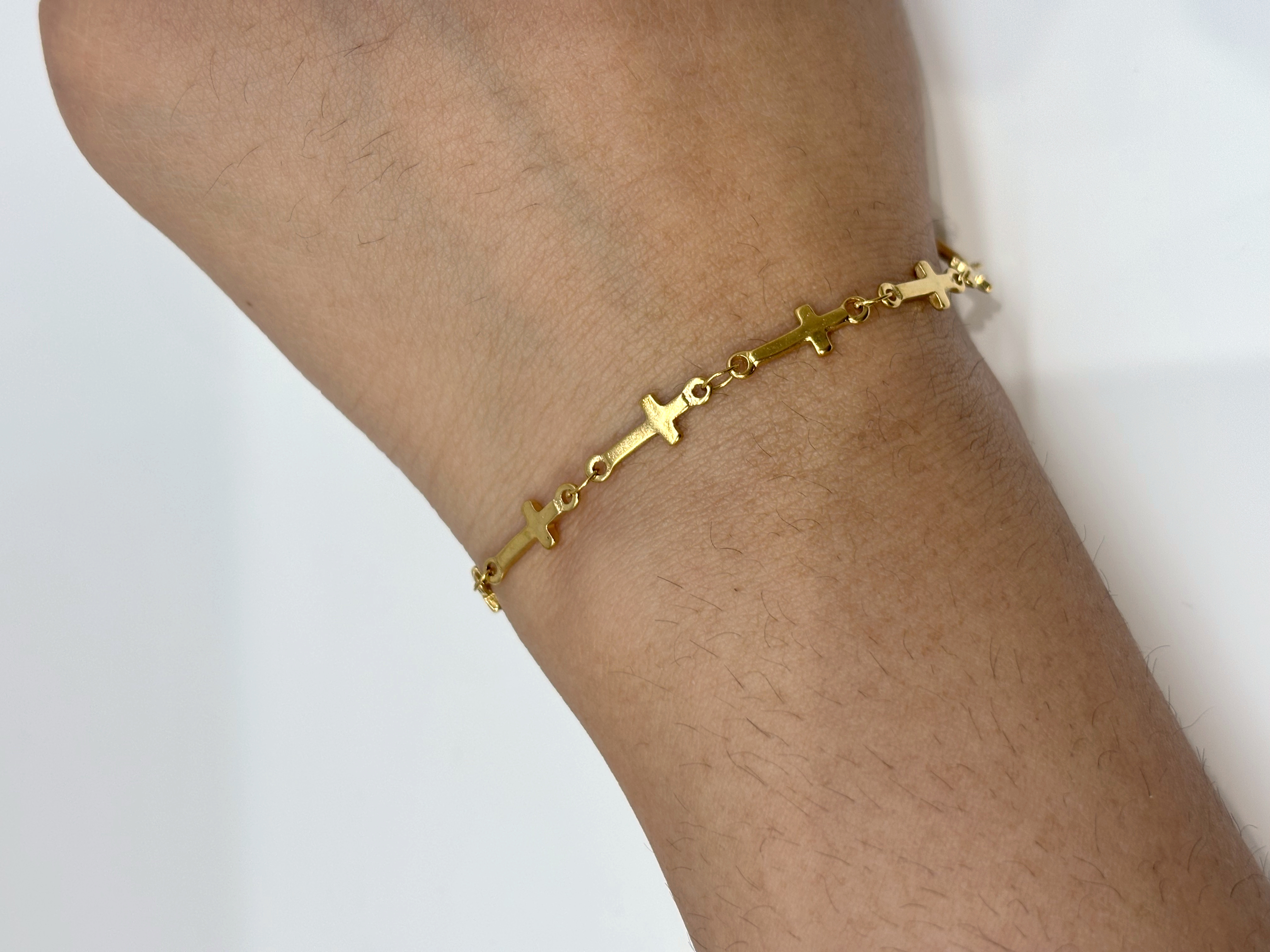 Cross Charm gold plated bracelet worn on wrist