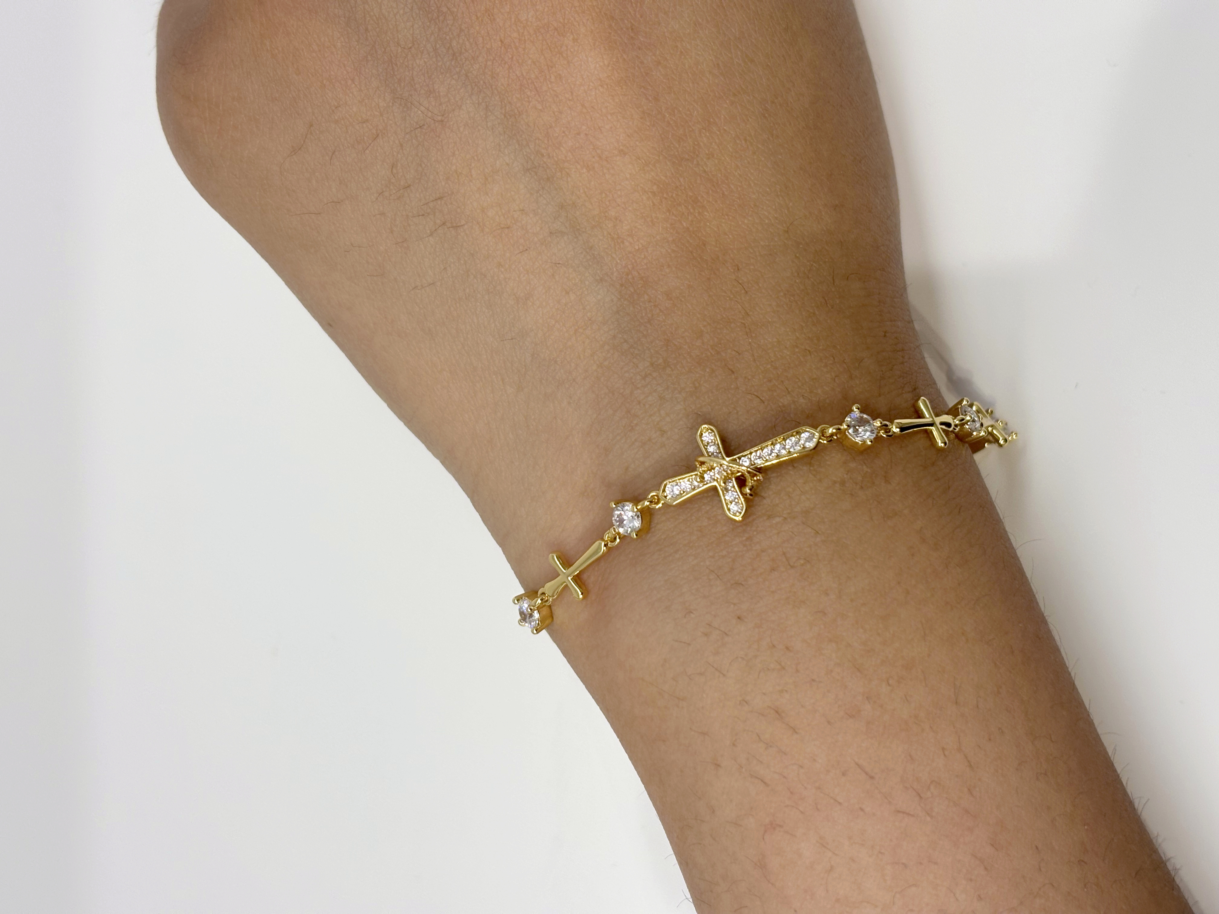 Cross Station gold plated bracelet worn on wrist