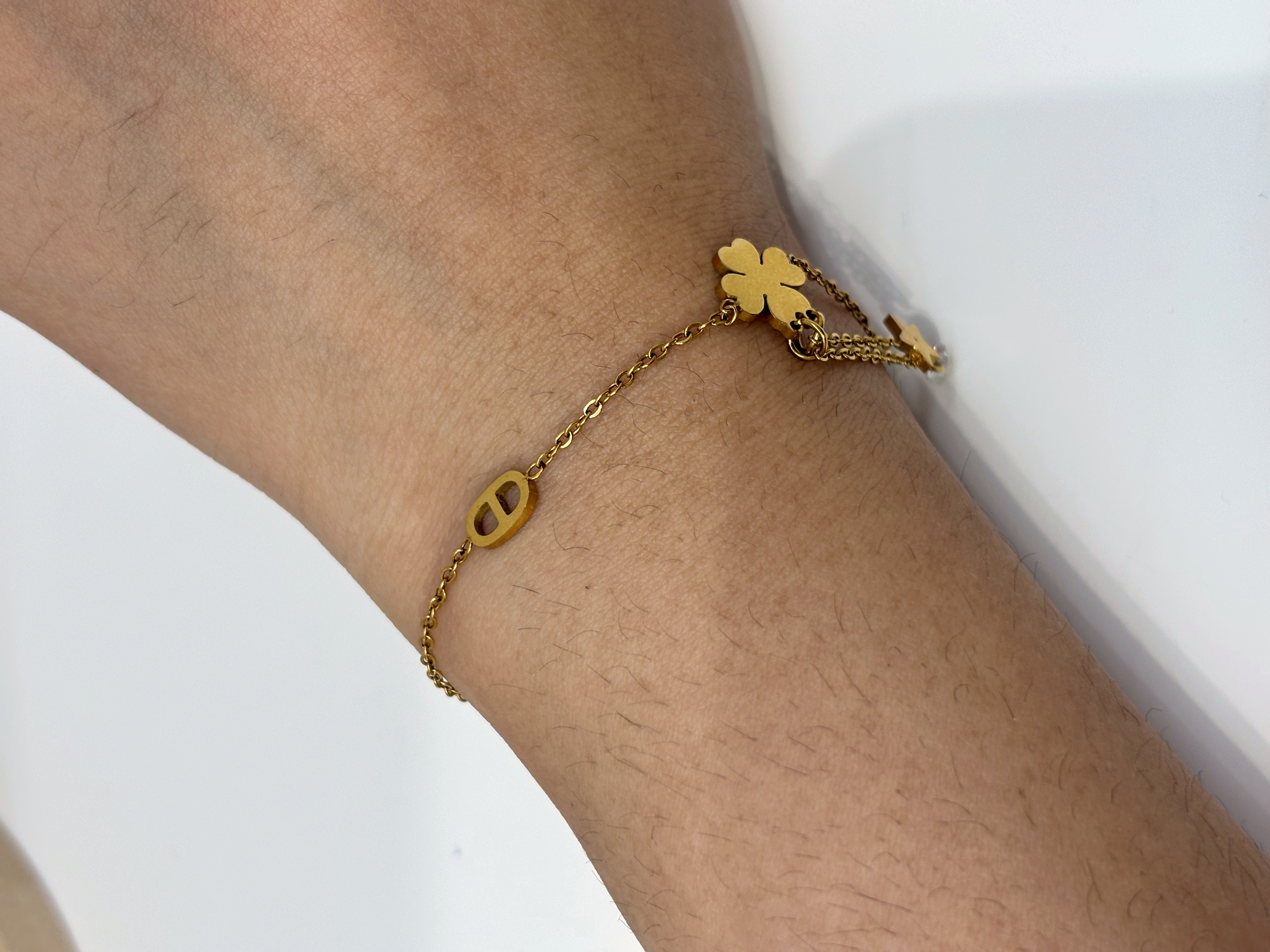 Flower and Star Drop gold plated bracelet worn on wrist