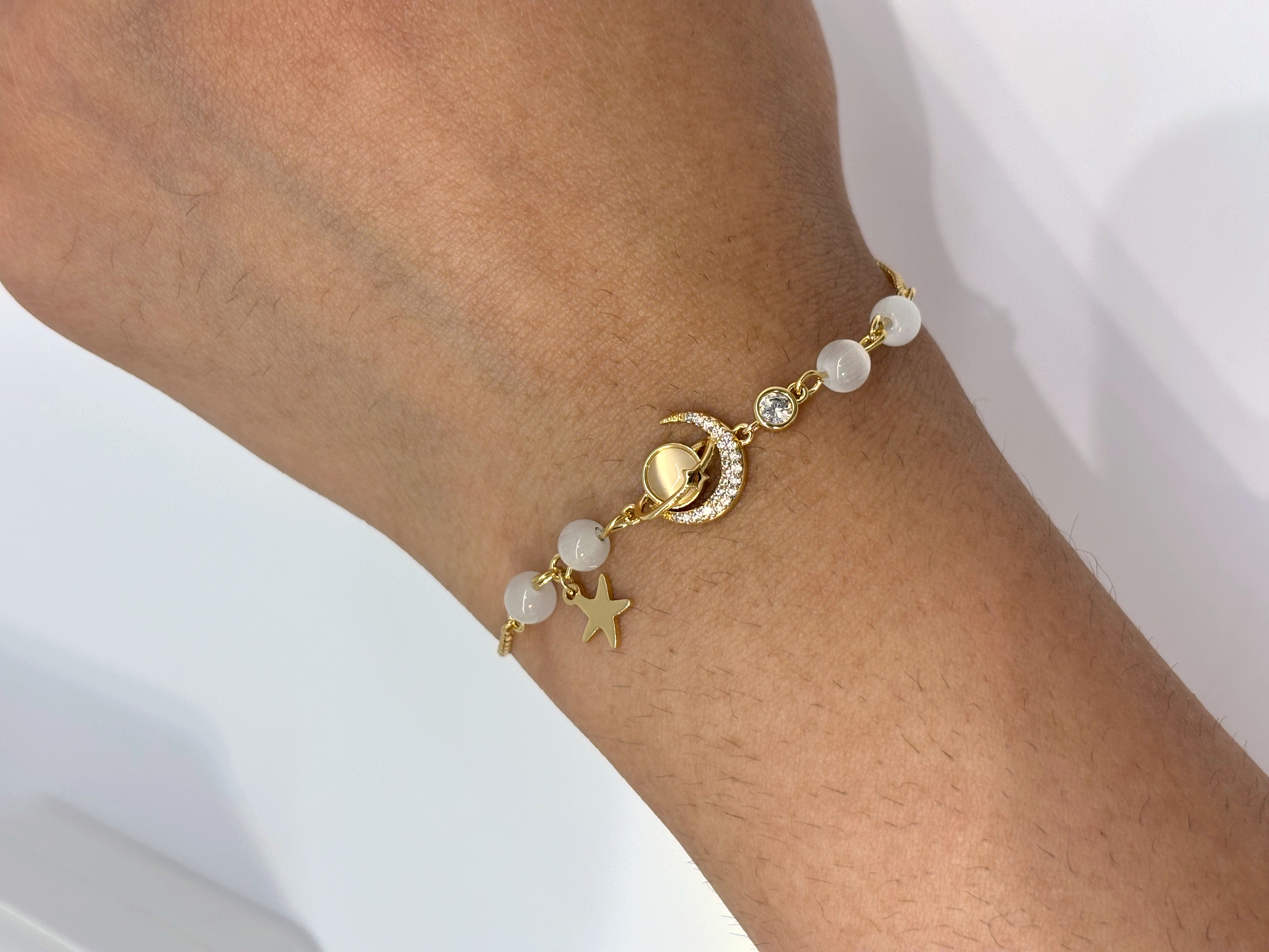 Moon and Star Charm gold plated bracelet worn on wrist